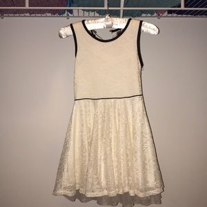 New,white laced sleeveless dress with a black trim